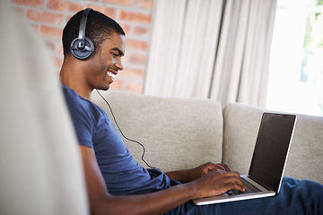 Image showing Man, online and music with laptop on sofa for movie streaming, podcast and internet games with listening. Happy, black person and technology with headphones for relax, studying and learning in lounge