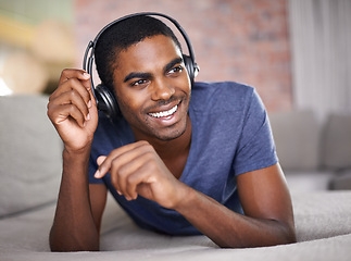 Image showing Man, portrait and smile with music on sofa for audio streaming, podcast or headset in living room of home. Student, black person or face with headphones for relax, radio subscription or rest on couch