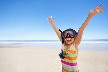 Image showing Girl, happy and goggles for celebration at beach, energy and equipment for snorkeling on holiday. Female person, child and victory on tropical vacation in outdoor, sand and blue sky for mockup space