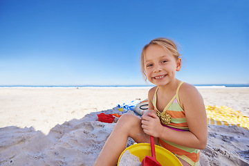 Image showing Happy, portrait and little girl with beach toys for playful holiday, summer vacation or outdoor weekend. Female person, child or young kid playing with smile, bucket and spade on sand or mockup space