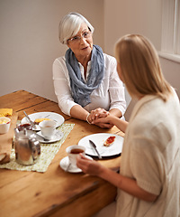 Image showing Mother, daughter and home with holding hands in table on lunch for bonding, support and visit. House, family and tea with food for conversation on break, leisure and happiness for coffee and care.