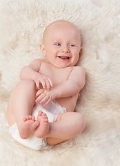 Image showing Baby, cute and laugh in bedroom, blanket and playtime in diaper for child development in happiness. Infant, kid and wellness for newborn, adorable and rug in house for home and toddler fun