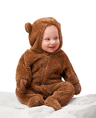 Image showing Studio, baby and onesie with costume, bear and toddler with joy and fun. Child, newborn and happiness with adorable, comfort and dressed up infant for development isolated on white background