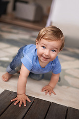 Image showing Floor, crawl and portrait of baby in home for fun playing, happiness and learning alone on ground. Relax, boy and face of a toddler with smile for child development, wellness or growth in a house