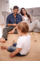 Image showing Family, couple and smile in lounge with toddler for growth, development and bonding on floor. Parents, caregivers and happy with little boy or child in home for activities, games and playing