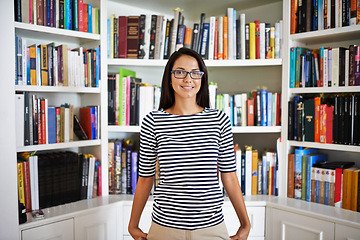 Image showing Woman, portrait and smile by bookshelf in house with books for reading, learning and knowledge in living room. Person, face and confidence by home library with magazine, journal and study collection