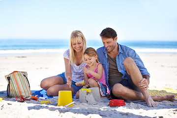 Image showing Mom, dad and girl with sandcastle at beach on vacation with care, learning and building on holiday in summer. Father, mother and daughter with plastic bucket with sand for game, play and happy by sea