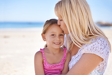 Image showing Portrait, mother and kiss happy kid at beach for holiday, summer or love on vacation at sea. Face, mom and smile of girl at ocean for adventure, travel or family bonding together outdoor in nature