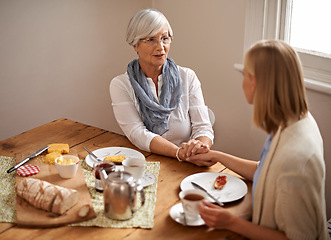 Image showing Senior mom, daughter and home with conversation in table for bonding, support and visit. Holding hands, family and meal with tea, food and chat on breakfast together with care, smile and love