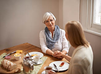 Image showing Mother, daughter and home with smile for holding hands in table for bonding, support and visit. Meal, family and tea with food for conversation on break, leisure and happiness for coffee and care.