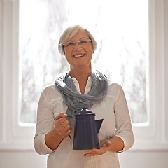 Image showing Senior, teapot and portrait with smile, kitchen and retirement with happiness and relaxing. Mature woman, kettle and glasses with joy, home and coffee or tea for routine and window in house.