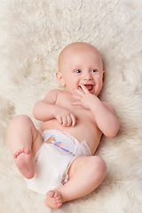 Image showing Happy baby, diaper and laugh in bedroom, furry blanket and playtime in cute for child development. Infant, kid and wellness for playing, adorable and positive on rug in house for home and toddler fun