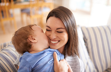 Image showing Mother, baby and kiss for love in embrace, care and support or relax in living room and comfortable. Mommy, son and affection for bonding in childhood, security and happiness in hug or smile on face