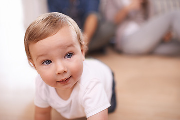 Image showing Young baby, crawling and portrait in family home, child and play on living room floor. Childhood development, growth and bonding or learning to move, mobility and education with support from parents