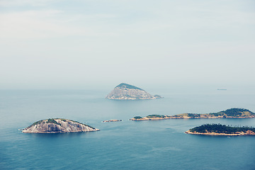 Image showing Ocean, nature and aerial of island in sea for travel, holiday and vacation destination in summer. Natural background, seascape and islands in water for scenic view in environment, ecosystem and waves