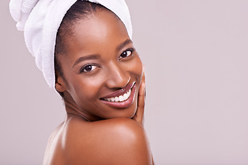 Image showing Hair towel, portrait and happy black woman in studio for skincare, wellness or body care on purple background. Beauty, cleaning or hands on face of African female model with cosmetic, shine or glow