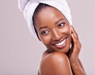 Image showing Happy, woman and skin care with towel in studio for beauty, dermatology and thinking of benefits. Soft, facial and glow of young model or African person with smile for cosmetics on a white background