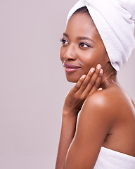 Image showing Black woman, space and hair towel in studio with skincare, wellness or beauty on purple background. Makeup, cleaning or hands on face of calm female model touching soft, skin or cosmetic glow results