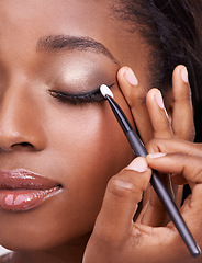 Image showing Closeup of black woman, brush and eyeshadow with makeup, beauty and lashes with eyeliner. Skin glow, hands and cosmetic product application with tools for cosmetology, shimmer or glitter with shine