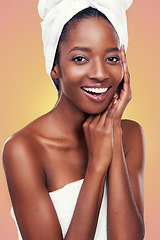 Image showing Hair towel, portrait and black woman in studio for skincare, wellness or body care on orange background. Beauty, cleaning or hands on face of African female model with cosmetic, shine or glowing skin