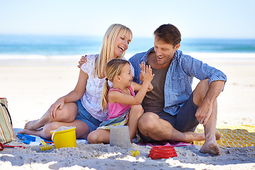 Image showing Family, beach and young girl on vacation, seaside and ocean with sand castle for bonding time. Holiday, overseas and summer season with parents, daughter and sunshine for happy memories in Hawaii