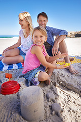 Image showing Parents, child and sandcastle in portrait at beach, blanket and excited with smile for holiday in summer. Father, mother and daughter with family picnic by ocean for vacation with love in sunshine