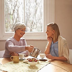 Image showing Family, mother and daughter with tea for drink, relaxing and communication with conversation. Happy people, women and smile with coffee at home in table or kitchen, talking and laughing in house