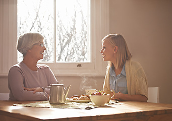 Image showing Talking, tea and grandmother with woman in home for brunch, bonding or visit in retirement. Senior, grandma and girl on coffee break with food, conversation and relax on holiday or vacation morning
