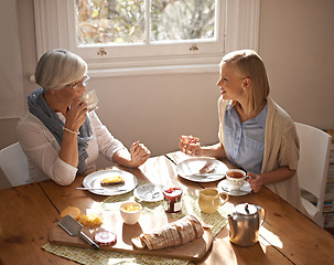 Image showing Happy woman, senior mother and eating breakfast, drinking coffee and conversation at home together. Smile, elderly mom and daughter with tea cup at table, food and family with healthy cheese on bread