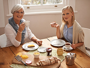 Image showing Portrait, happy woman and senior mother drinking tea at breakfast, bonding and smile in house. Face, elderly mom and adult with coffee cup at table, food and family eating bread at home together