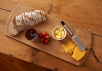 Image showing Breakfast, board and cheese with jam, bread and fresh strawberry for diet, nutrition and gourmet morning snack. Food, fruit and high angle of sweet, savory and delicious rustic brunch on charcuterie.