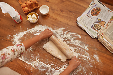 Image showing Dough, recipe and hands with rolling pin on table, above baking in kitchen and closeup on process in bakery. Person, prepare and press bread with flour and meal prep with information guide in book