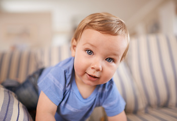 Image showing Toddler, crawling and portrait of baby in sofa or home for fun playing or learning in living room. Energy, boy or face of a curious male kid outside for child development or growth in a house alone