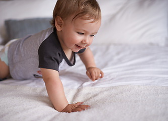 Image showing Boy, baby and learning to crawl in home, bed and kid for motor skills in bedroom on weekend. Child development, happy toddler and calm or comfortable, wellness and curious for health and growth