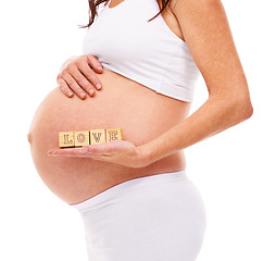 Image showing Mother, pregnancy and blocks with love in studio for care, support and future child. Pregnant woman, belly and holding stomach with baby for wellness, gratitude and maternity on white background