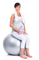 Image showing Pregnant female person, fitness and ball for studio, wellness and exercise for motherhood in pregnancy. Maternal woman, water and white background for health, maternity and towel to keep in shape