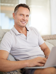 Image showing Man, laptop and portrait on patio in home, chair and typing with search for movies on website. Person, computer and relax on couch, scroll and happy for streaming subscription on holiday at apartment