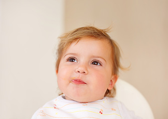 Image showing Happy, baby and eating as thinking of food, tasty and messy for healthy, childhood and development. Smile, cute child and hungry for meal, delicous and nutrition for wellbeing, health and growth