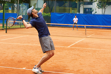 Image showing Exercise, sports and tennis with man serving on clay court to start competition or game from back. Fitness, training or workout and athlete man with racket in stadium or venue at beginning of match