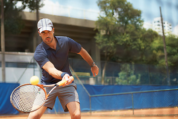 Image showing Fitness, sports or tennis and man with racket hitting ball on court for competition, game or match. Exercise, health and training with confident young athlete person outdoor in summer for action