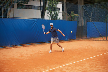 Image showing Exercise, sports or tennis and man with racket hitting ball on court for competition, game or match. Fitness, health and training with confident young athlete person outdoor in summer for action