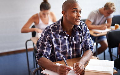 Image showing Black man, student and writing with book in classroom for studying, reading or summary at university. African male person or young academic writer with notebook for assignment, test or exam at campus