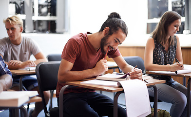 Image showing Man, class and writing notes in college, learning and knowledge on campus for education. Students, people and reading for information in book, planning and research for studying or revision for exams