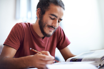 Image showing University, student and man reading textbook for education with scholarship, smile and studying. Male person, happy and learning for information with research on table or desk of classroom in academy