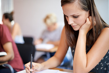 Image showing University, student and woman writing on notebook in academy for education with scholarship. Female person, exam and classroom for learning, knowledge and information from research for girl on desk