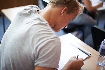 Image showing Man, class and writing in college, assessment and knowledge on campus for education. Student, male person and notes for information by back, planning and research for studying or revision for exams