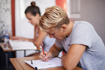 Image showing Man, student and writing with book in classroom for studying, reading or summary at university. Male person or academic writer taking notes for assignment, test or literature exam on desk at campus