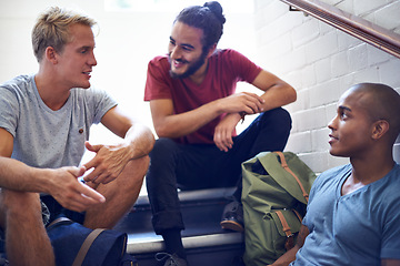 Image showing Happy man, student and friends talking on stairs with group for conversation, social interaction or chat at campus. University people or male person with smile on staircase for discussion at college