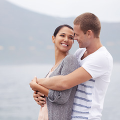 Image showing Couple, hug on beach and smile for travel, fresh air with ocean and happiness together outdoor. Romantic adventure, love and affection for bonding, support and trust with commitment on holiday