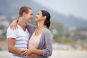 Image showing Love, romance and dating for couple at beach for leisure, bonding or vacation. Partners, mates and relationship with smile and hug for kiss and affection against blurred background and mockup